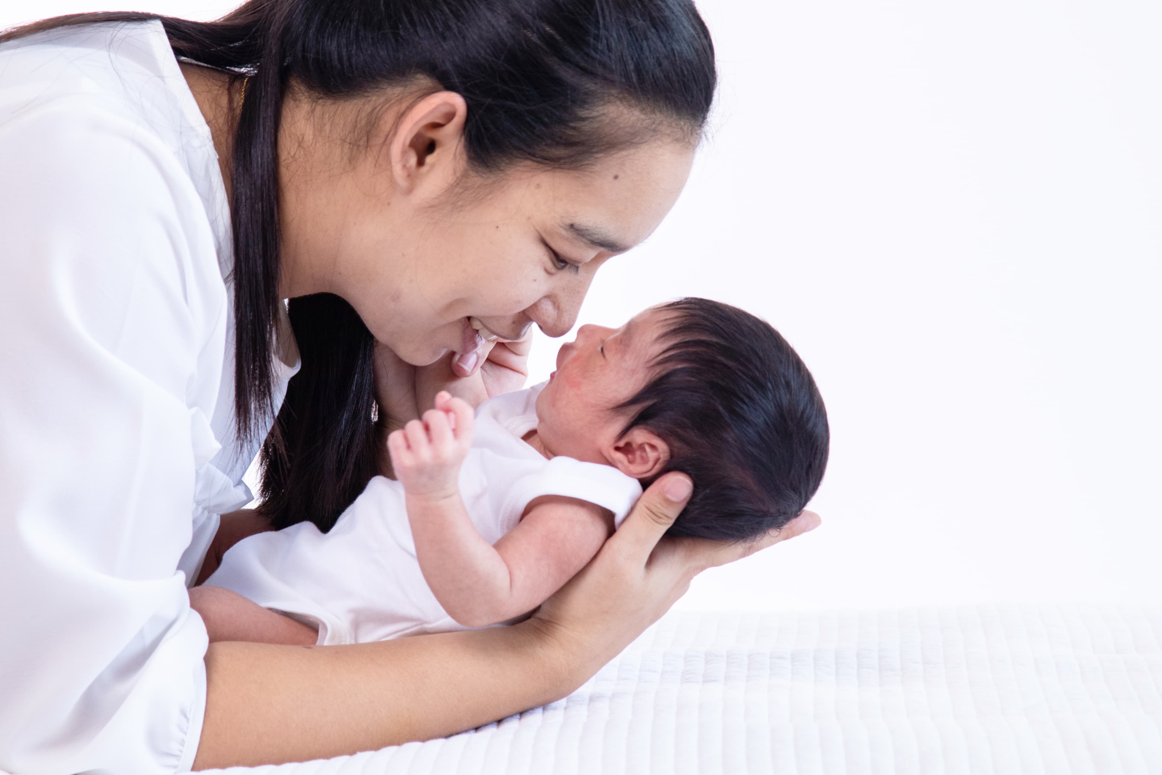 Young mother kissing her newborn baby girl